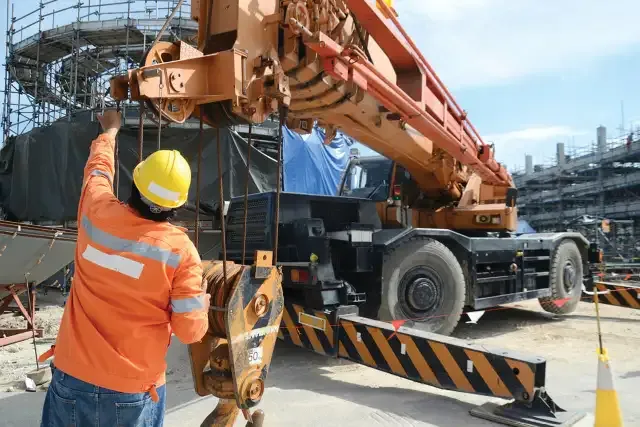Rigger signaling a mobile crane operator during a lift